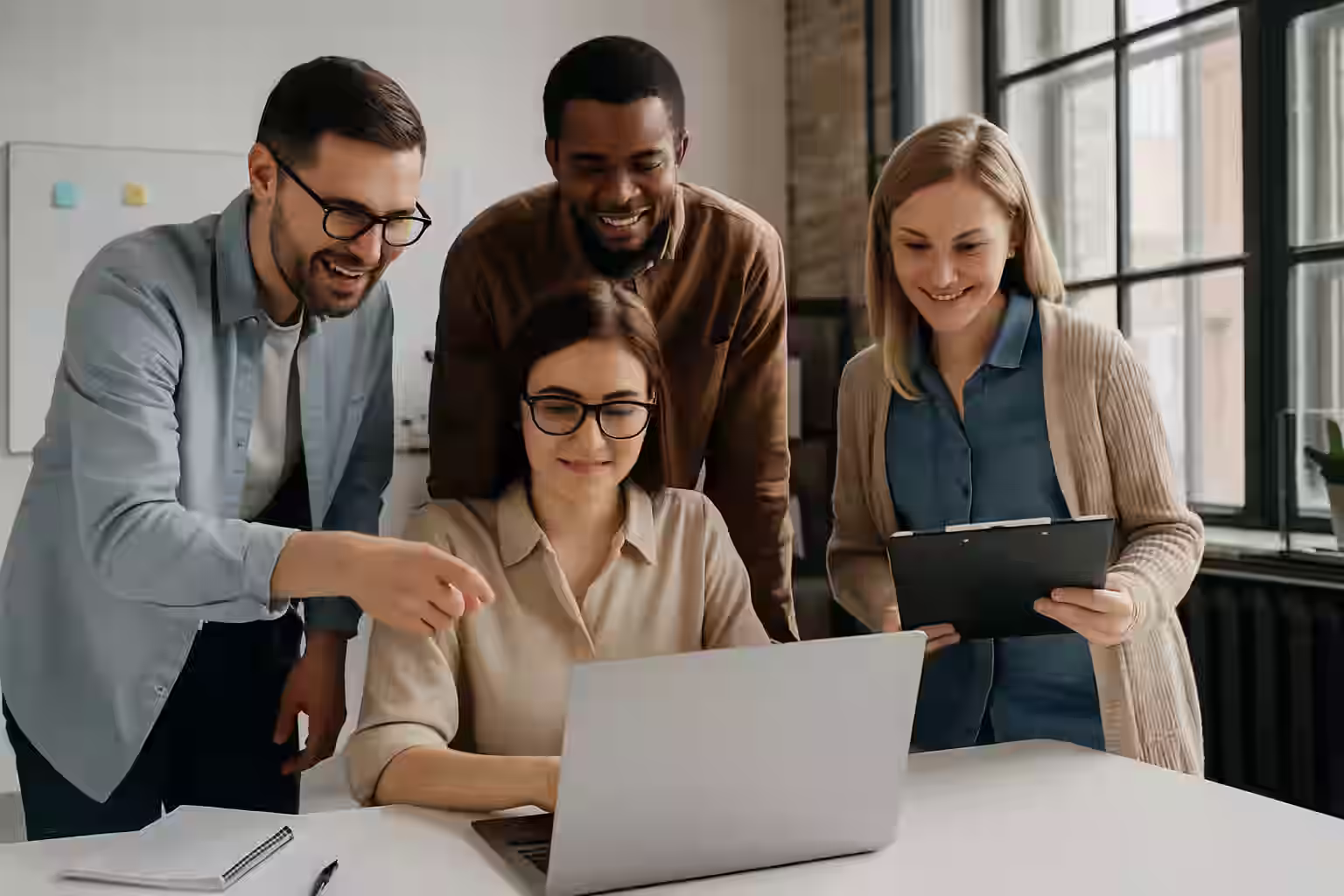 A photograph captures four individuals collaborating in a modern tech workspace, analyzing data on laptops and testing hardware components — representing a real-world beta testing environment.